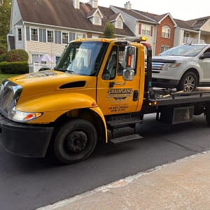 Flatbed towing white SUV